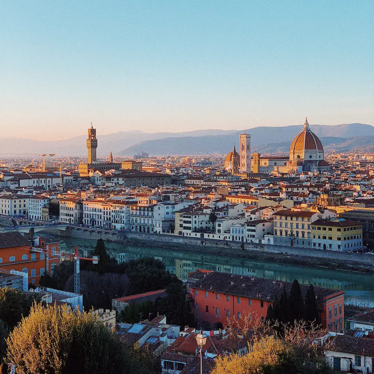 Vue panoramique d’une ville historique au coucher de soleil avec cathédrale à dôme doré et fleuve traversant l’agglomération