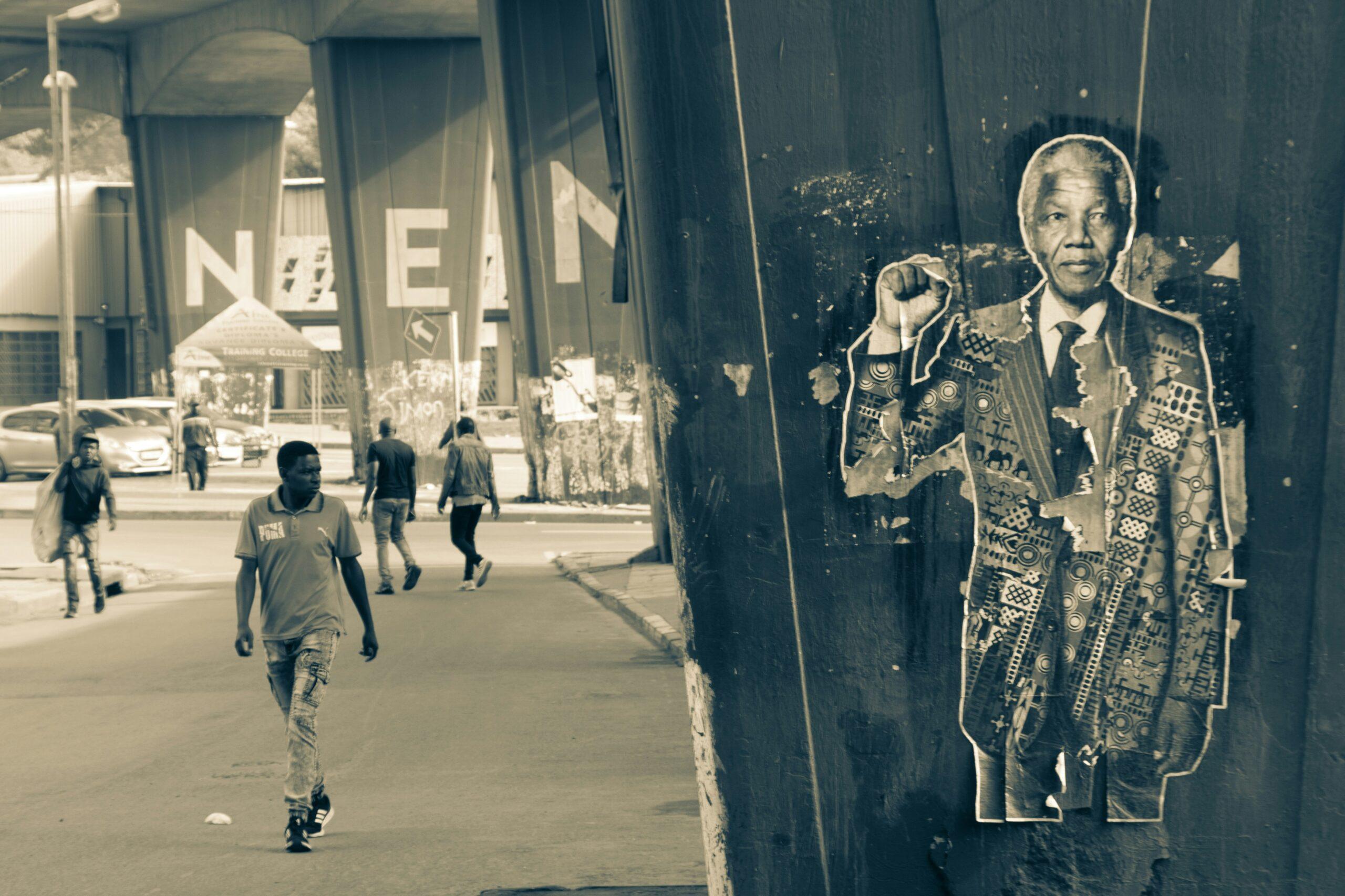 Street art portrait sur un mur urbain avec passants dans une rue de Johannesbourg