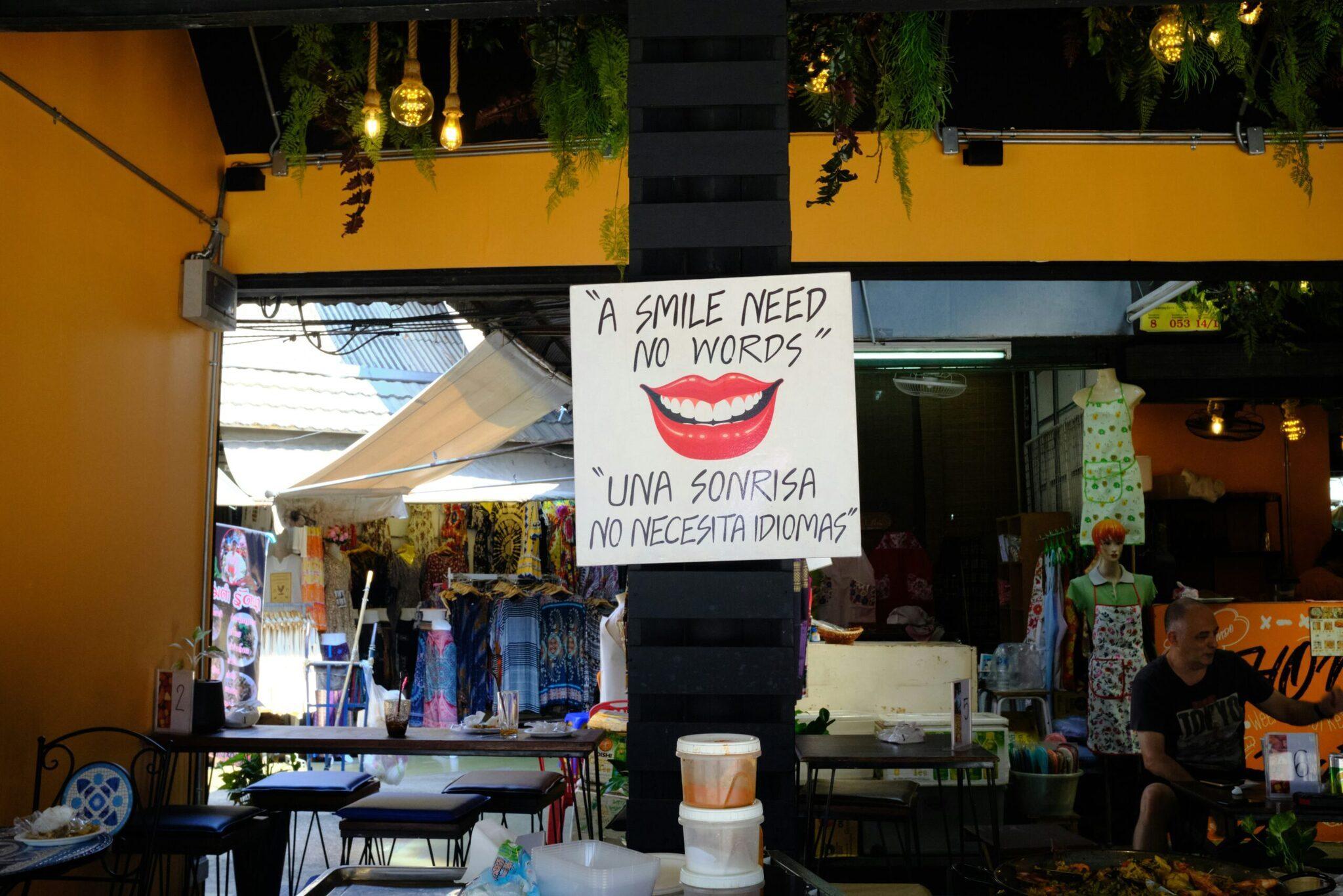 Devanture d’une boutique colorée dans une rue commerçante avec enseigne bilingue anglais-espagnol et décoration jaune vif