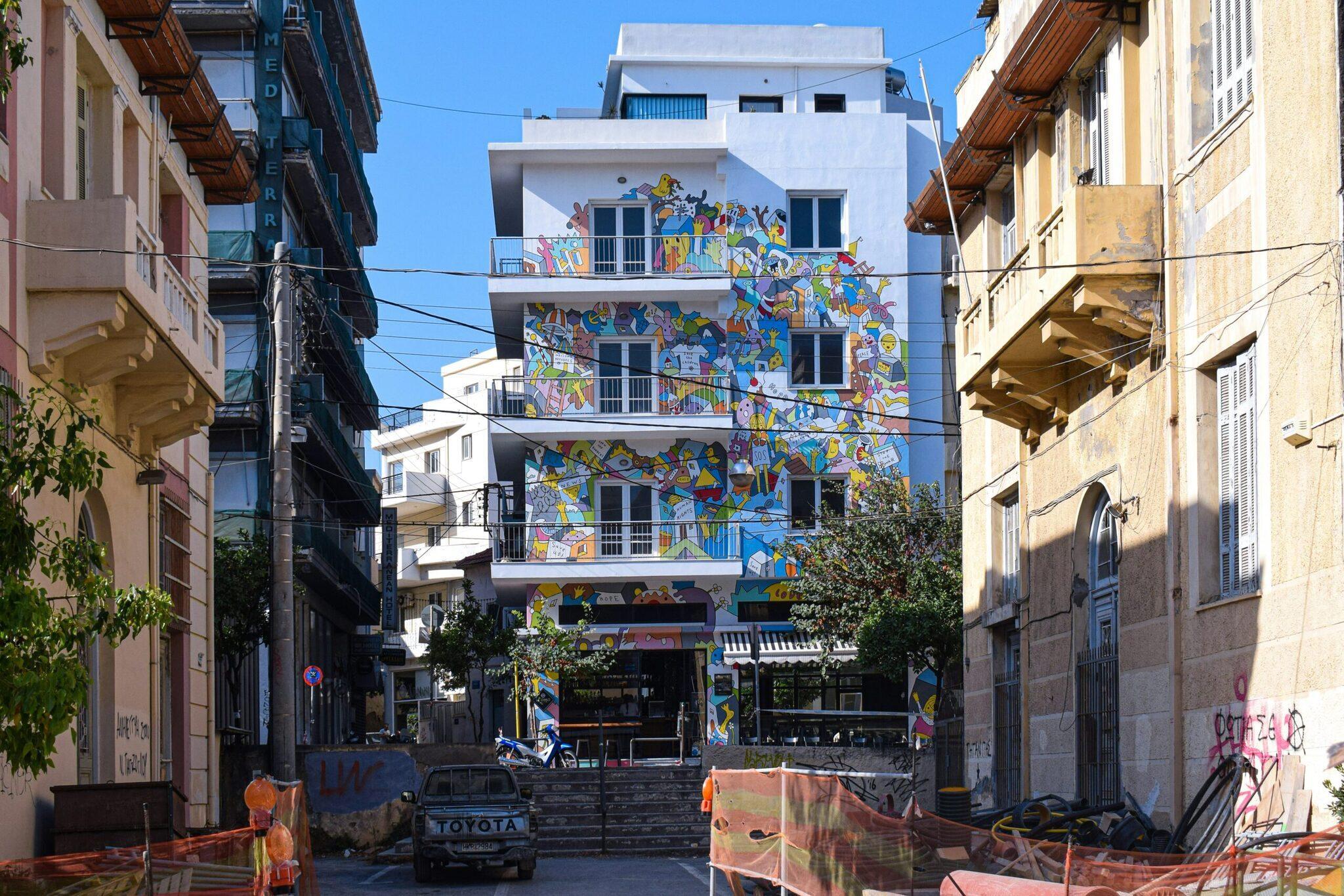 Immeuble moderne aux murs colorés couverts de street art dans une ruelle étroite d’une ville méditerranéenne