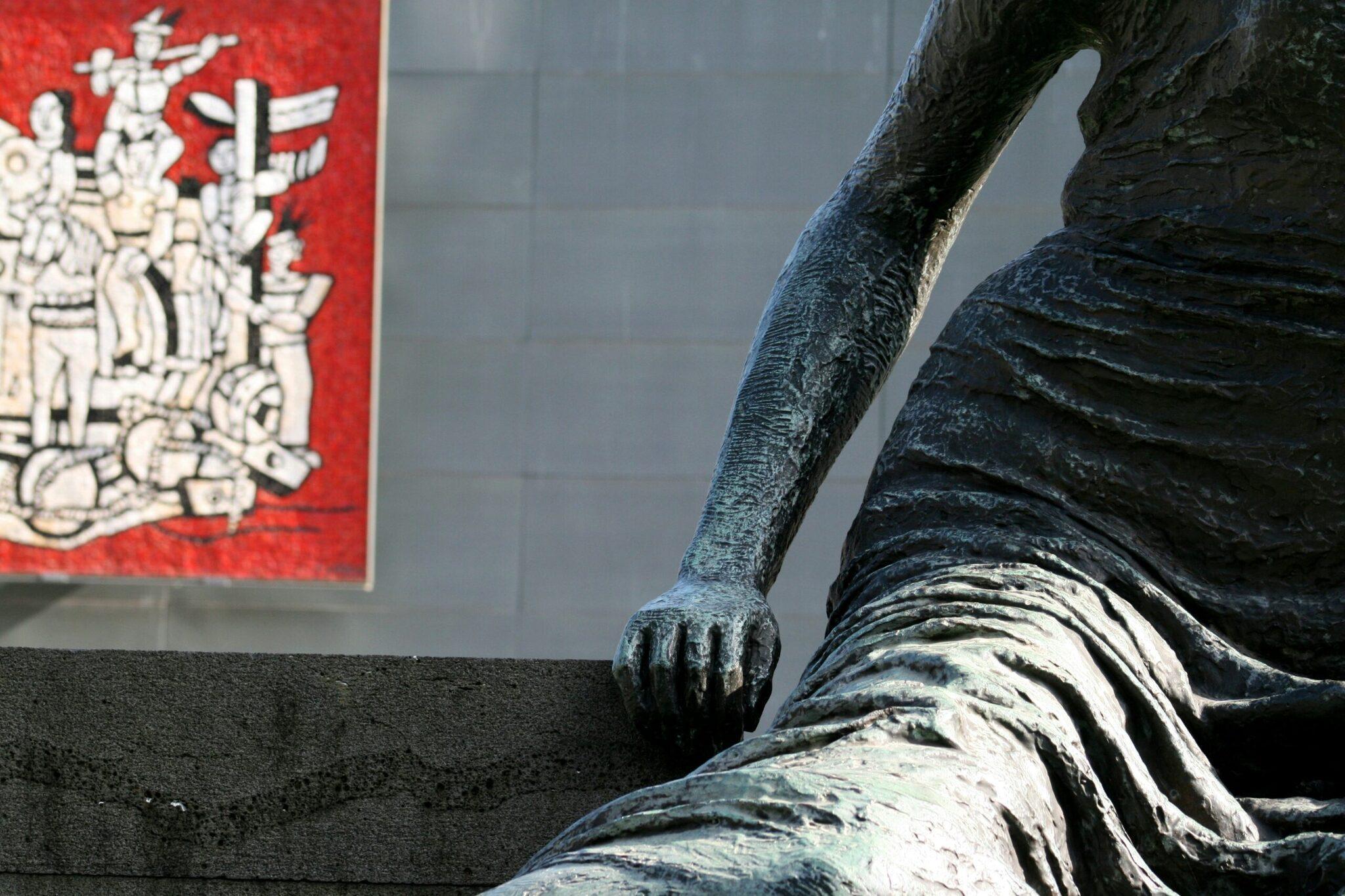 Détail d’une statue bronze avec inscriptions asiatiques sur panneau rouge en arrière-plan