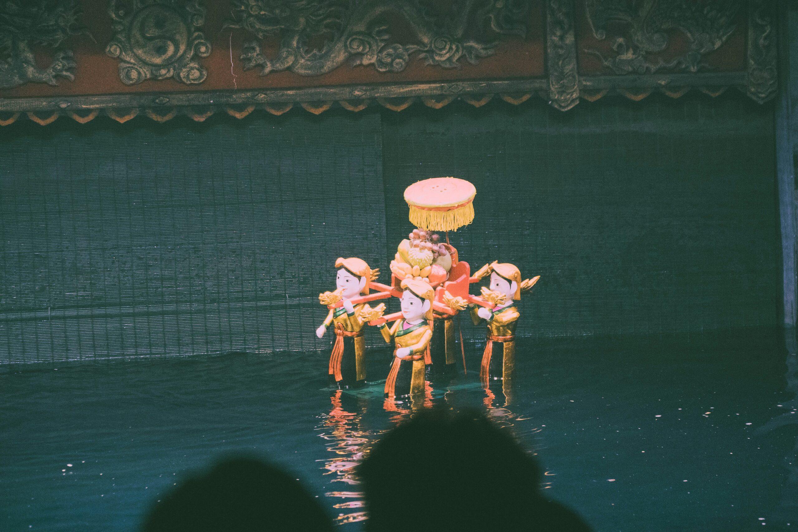 Spectacle de marionnettes sur l’eau traditionnel vietnamien avec des personnages en costumes dorés et décors colorés