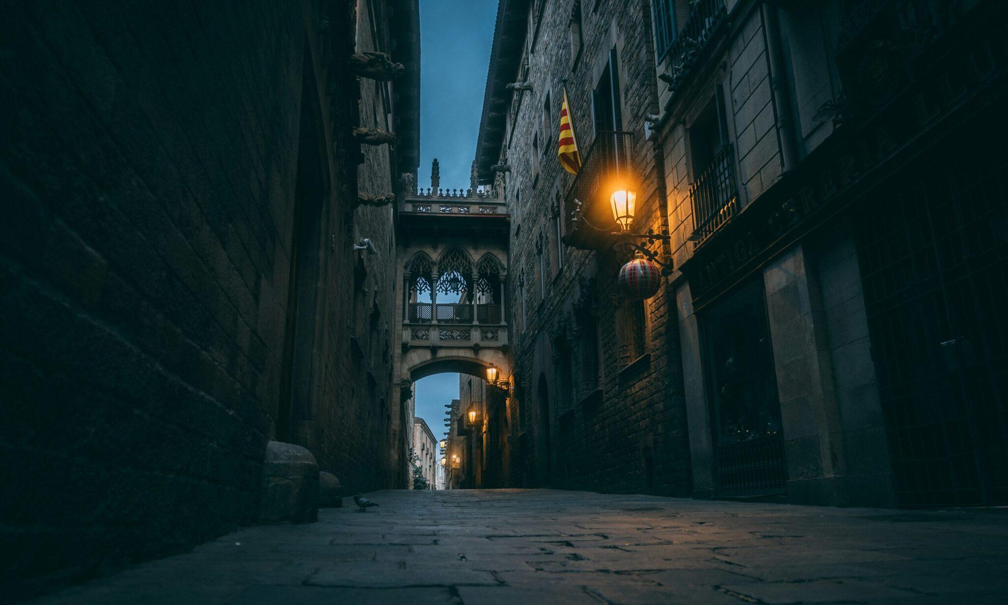 Ruelles gothiques étroites du quartier ancien de Barcelone au crépuscule avec lampadaire et drapeau catalan