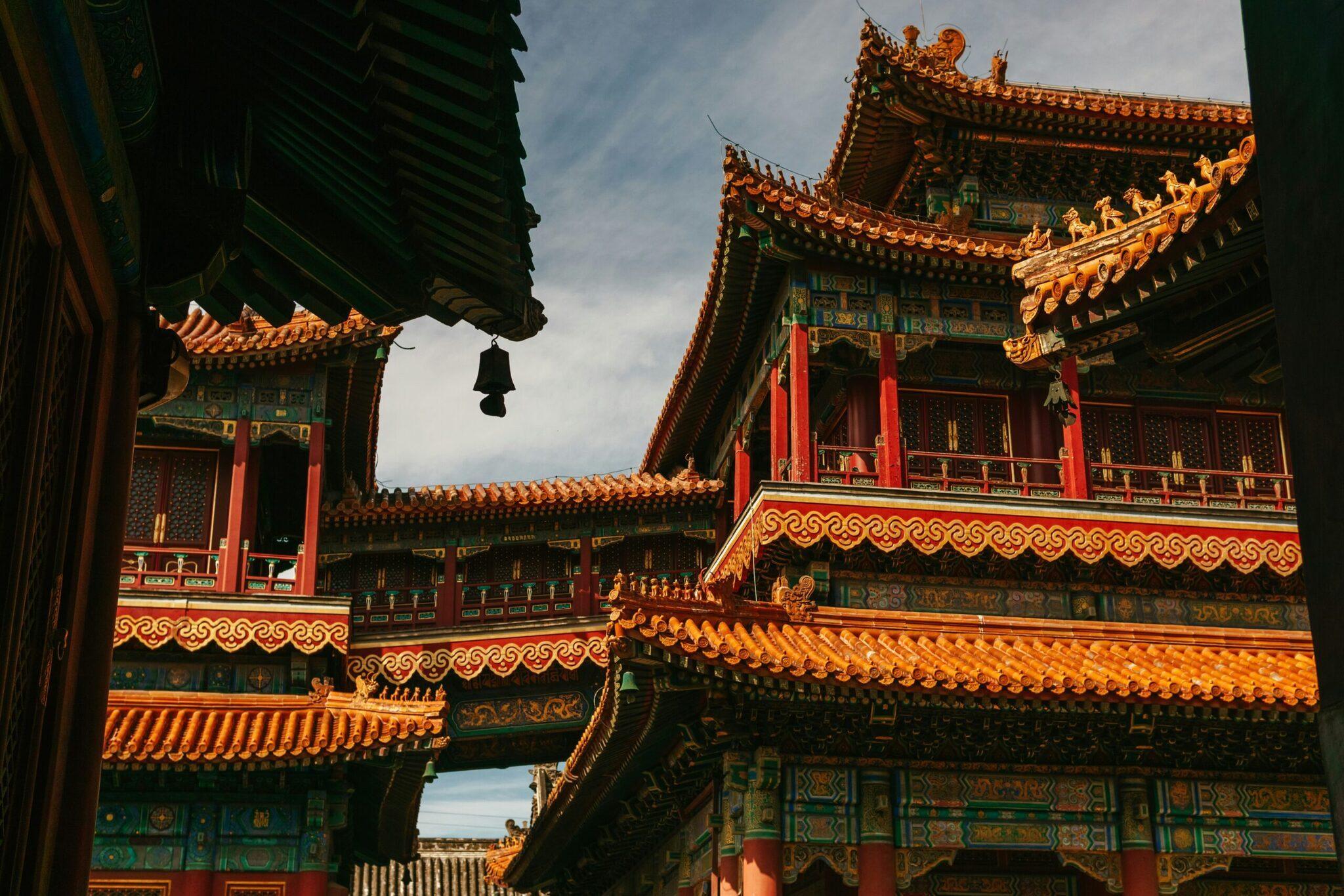 Cour intérieure d’un temple chinois avec toitures dorées ornées et architecture traditionnelle rouge et verte