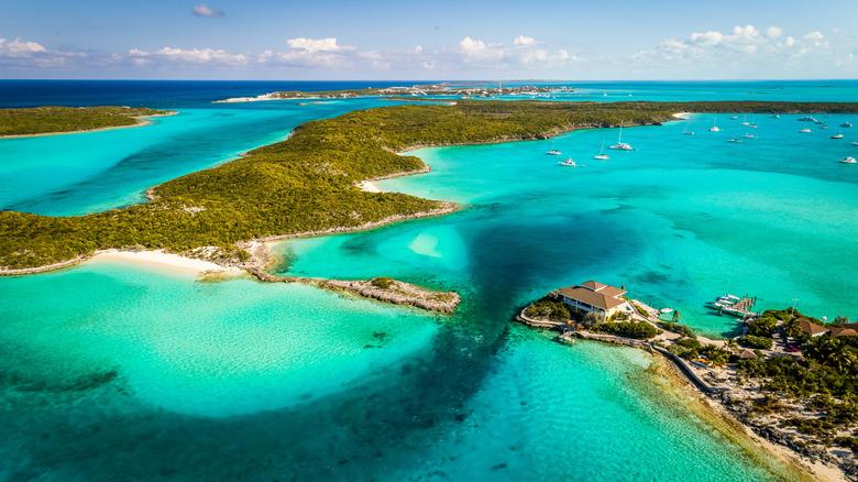 Vue aérienne d’archipel tropical aux eaux turquoise cristallines avec îles boisées, plages blanches et bateaux ancrés
