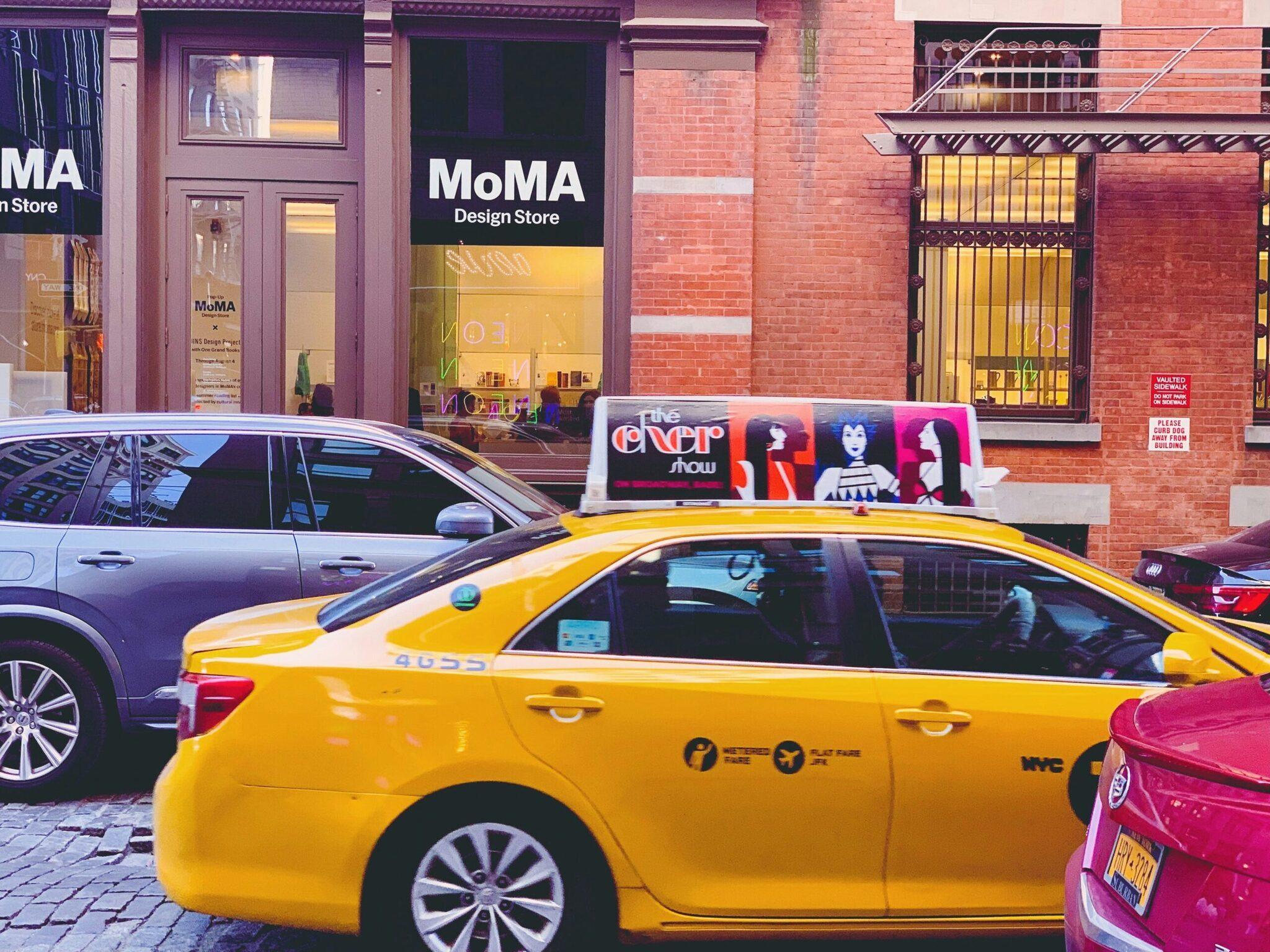 Une rue commerçante urbaine avec des taxis jaunes, des vitrines de magasins modernes et de l’architecture en briques rouges