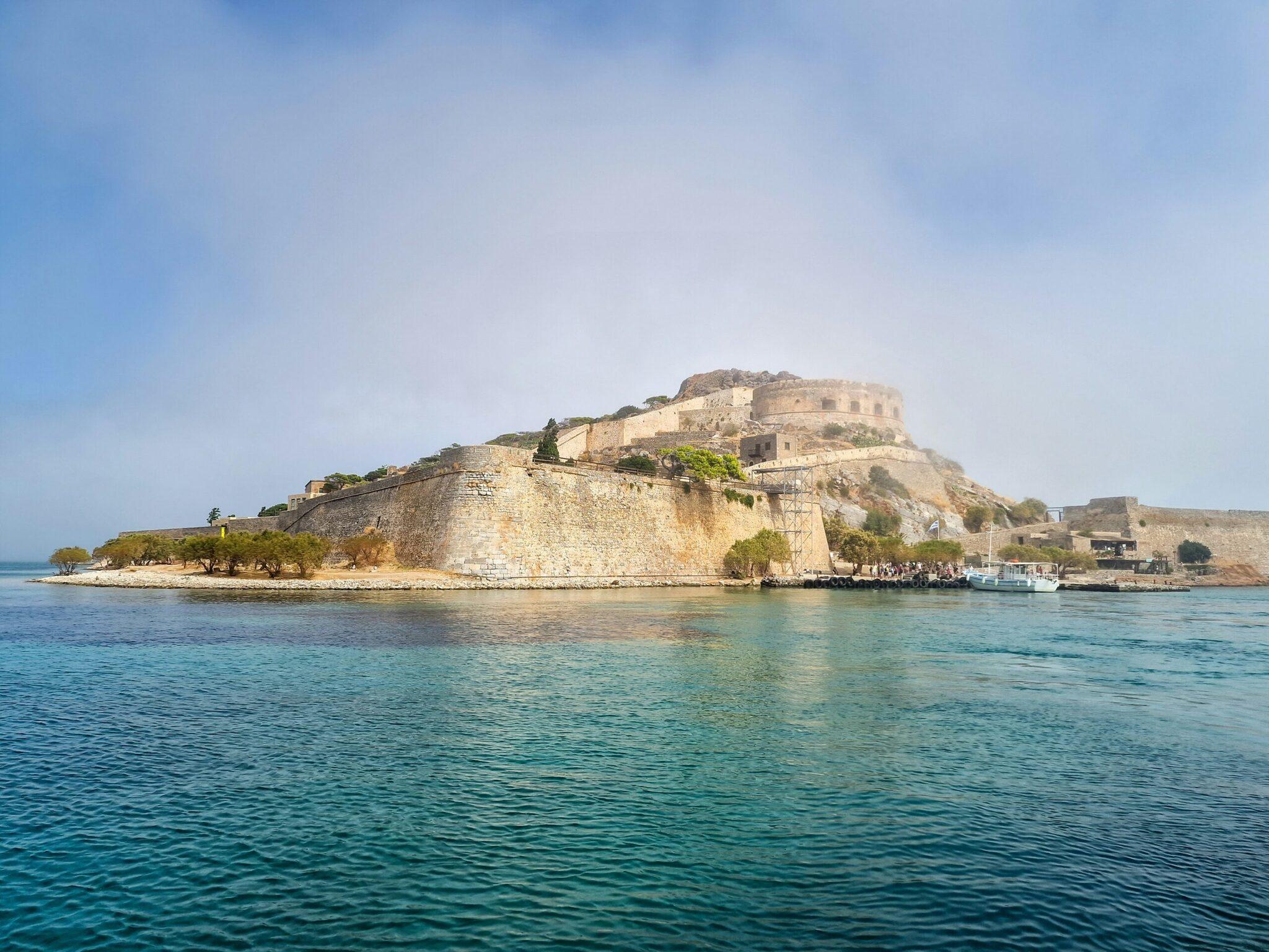 Forteresse vénitienne sur une presqu’île rocheuse entourée de mer turquoise en Crète
