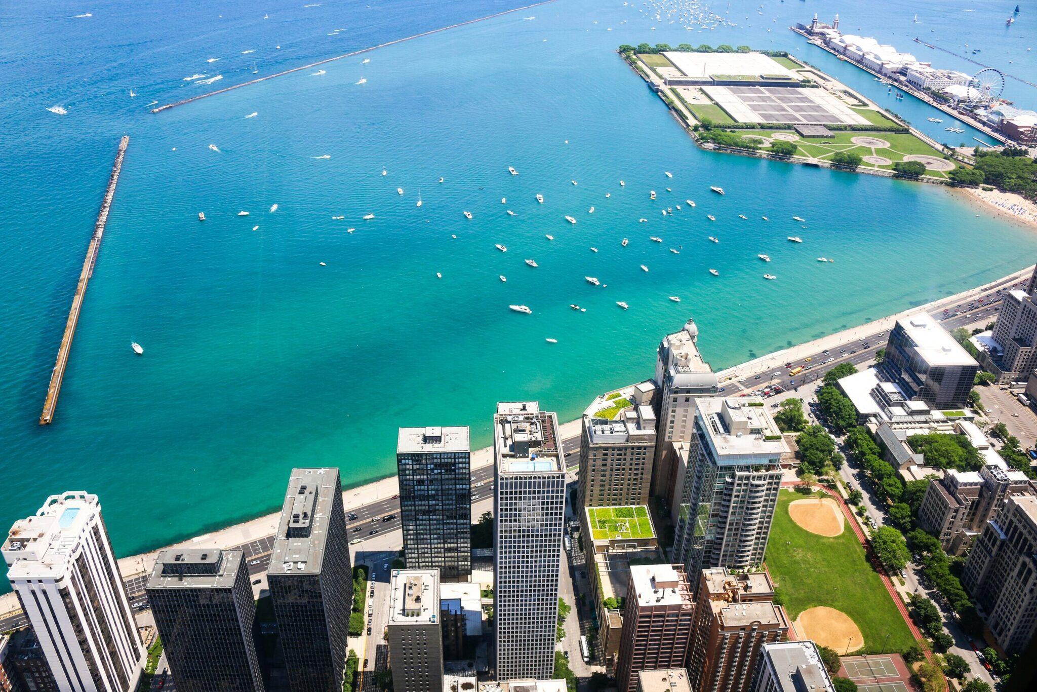 Vue aérienne du front de mer de Chicago avec gratte-ciel, plage, lac turquoise et bateaux de plaisance amarrés