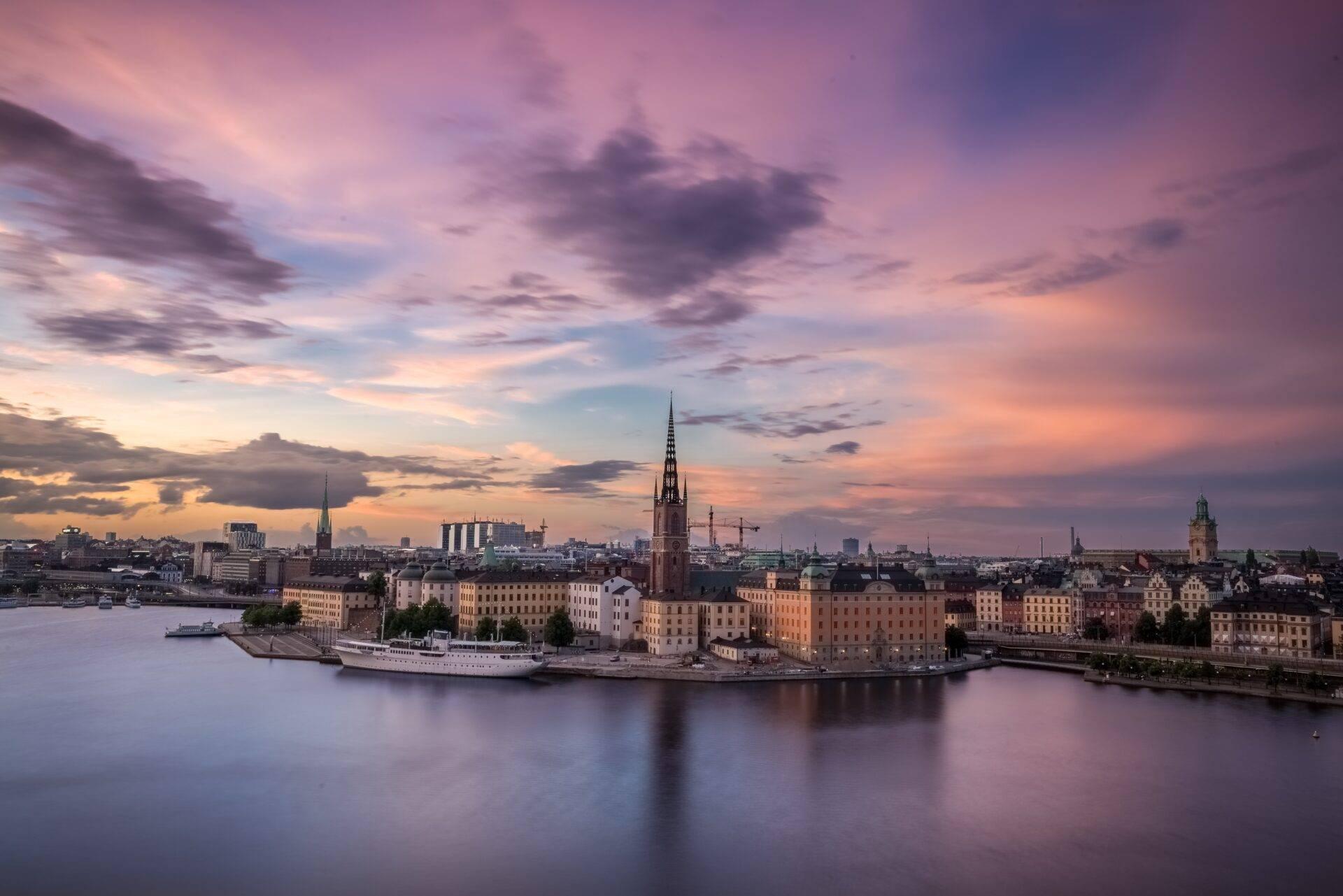 Vue panoramique d’une île historique avec églises, bâtiments colorés et navire au coucher de soleil
