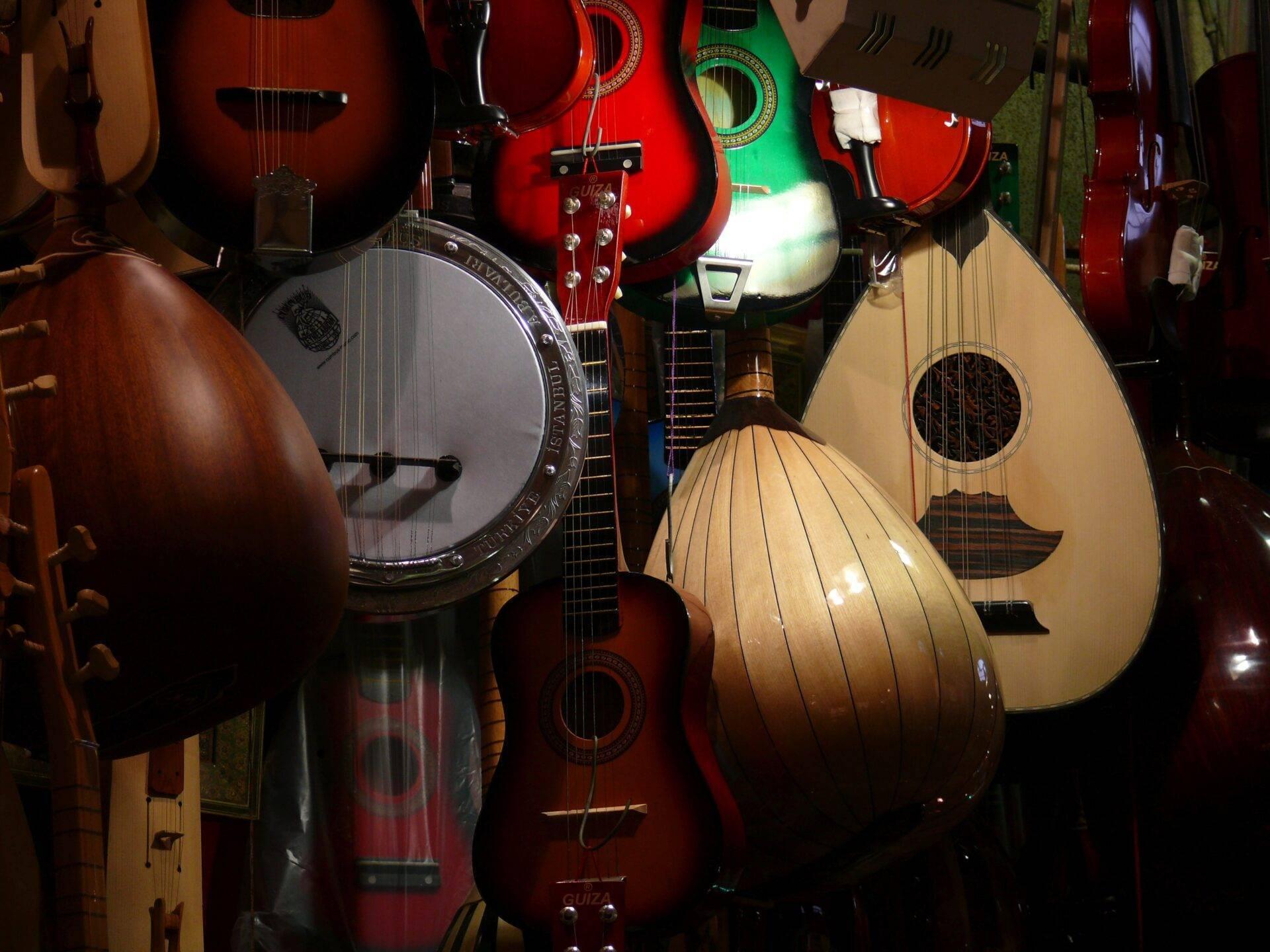 Collection d’instruments à cordes traditionnels turcs exposés dans une boutique de musique, incluant des oud et des luth orientaux
