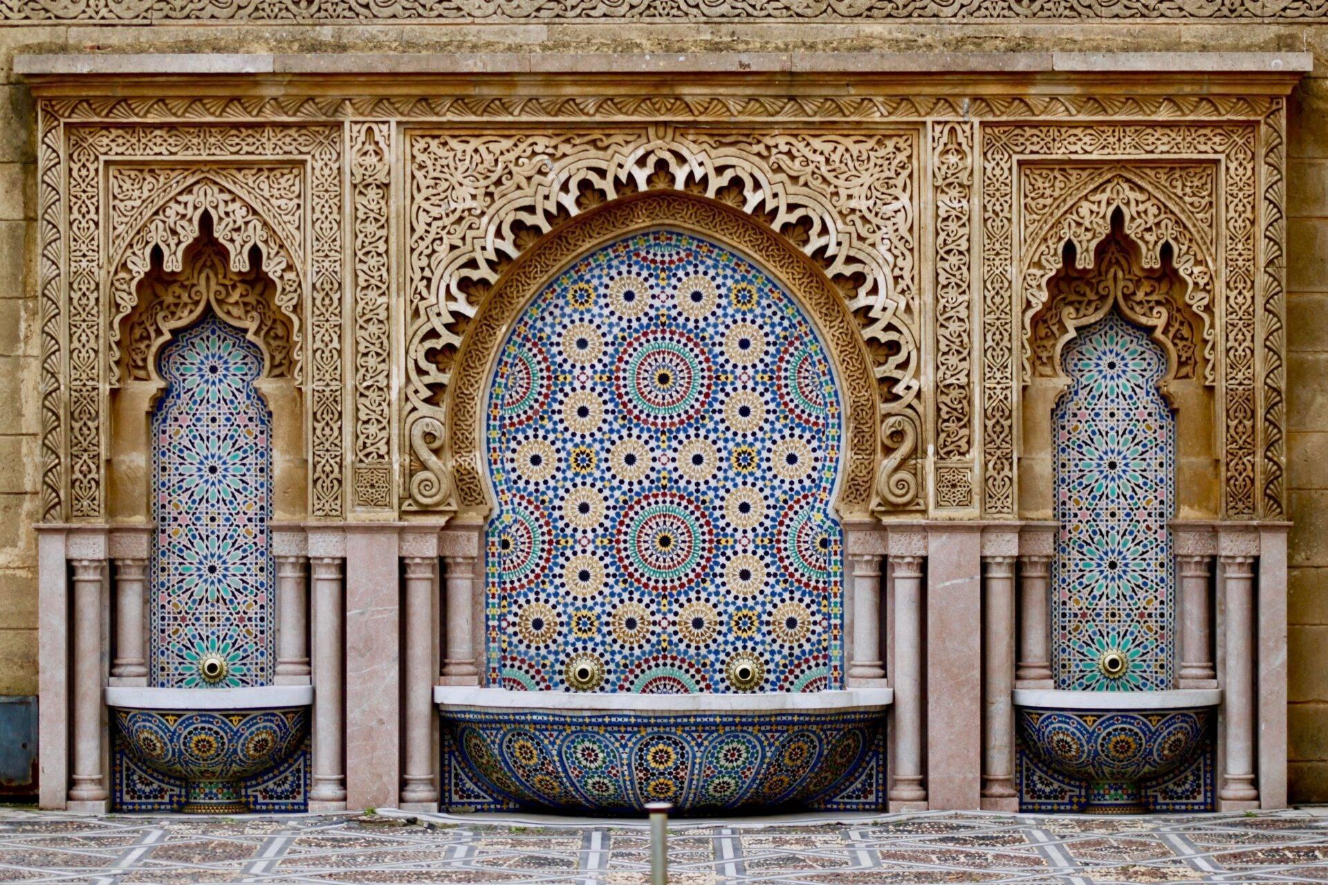Trois fontaines ornées de zelliges bleus et de bois sculpté dans un style architectural marocain traditionnel