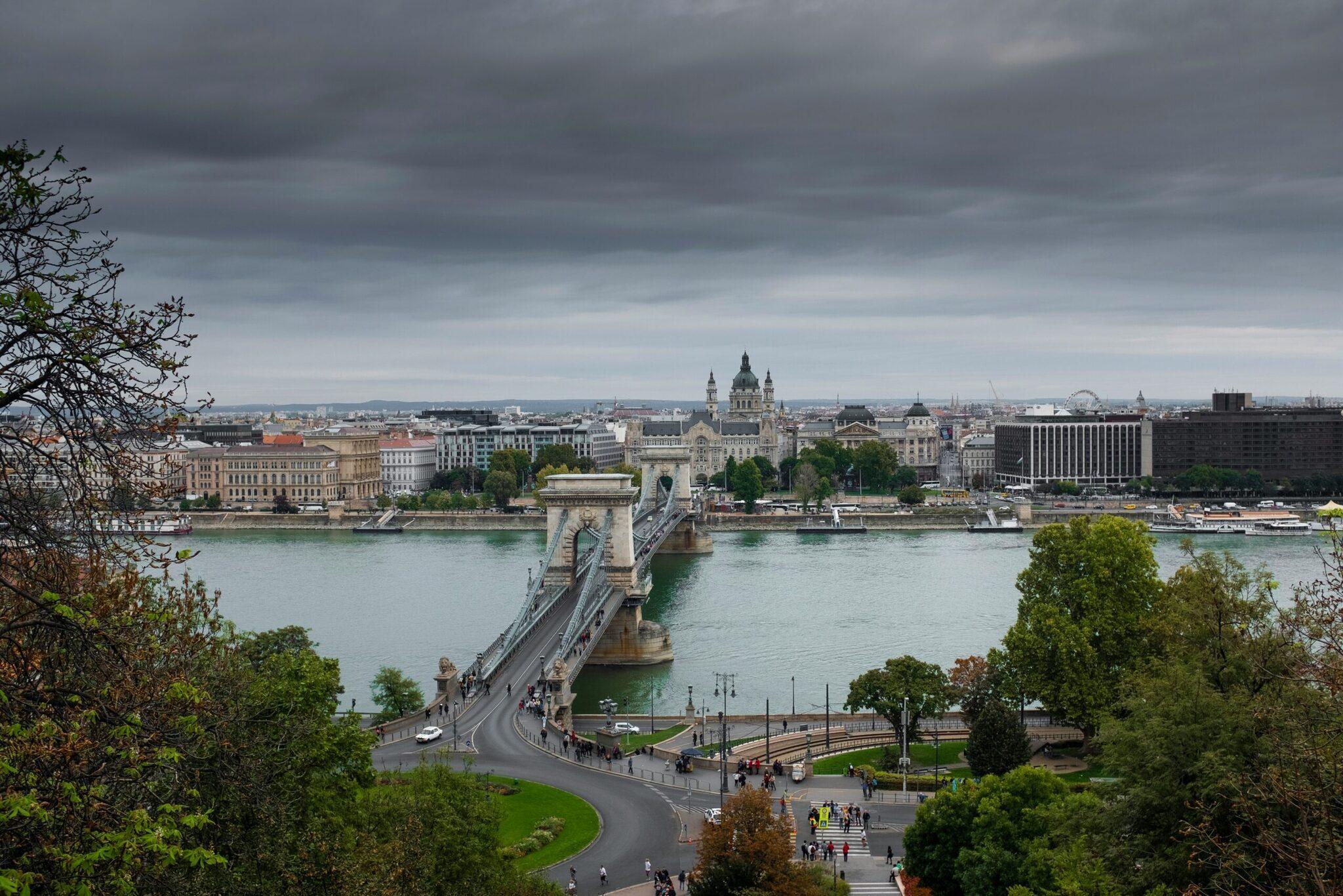 Vue panoramique d’un pont de pierre traversant un fleuve avec une basilique majeure et des bâtiments historiques en arrière-plan