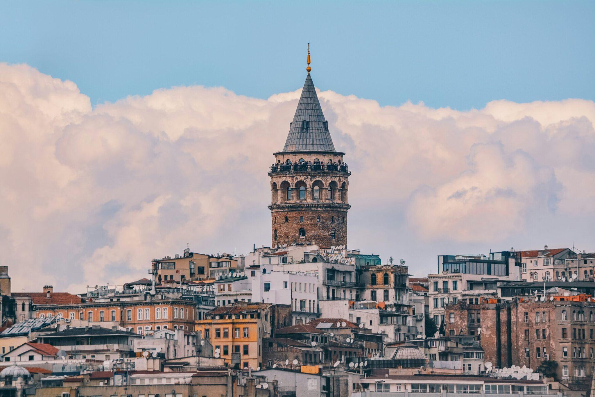 La tour de Galata dominarate skyline d’Istanbul avec ses bâtiments historiques colorés sous un ciel nuageux