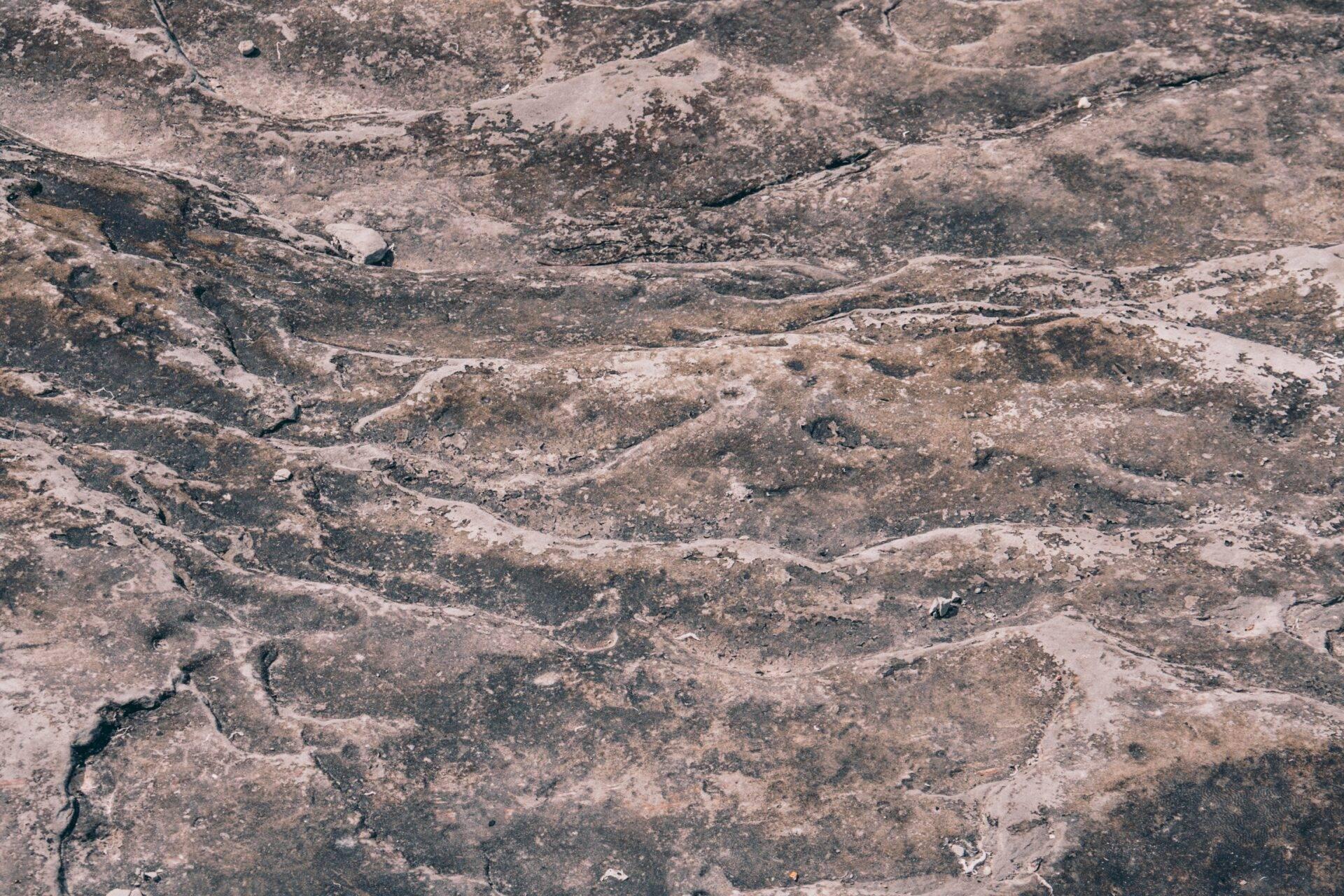 Paysage montagneux rocheux et aride avec relief accidenté et quelques traces de sentiers traversant le terrain