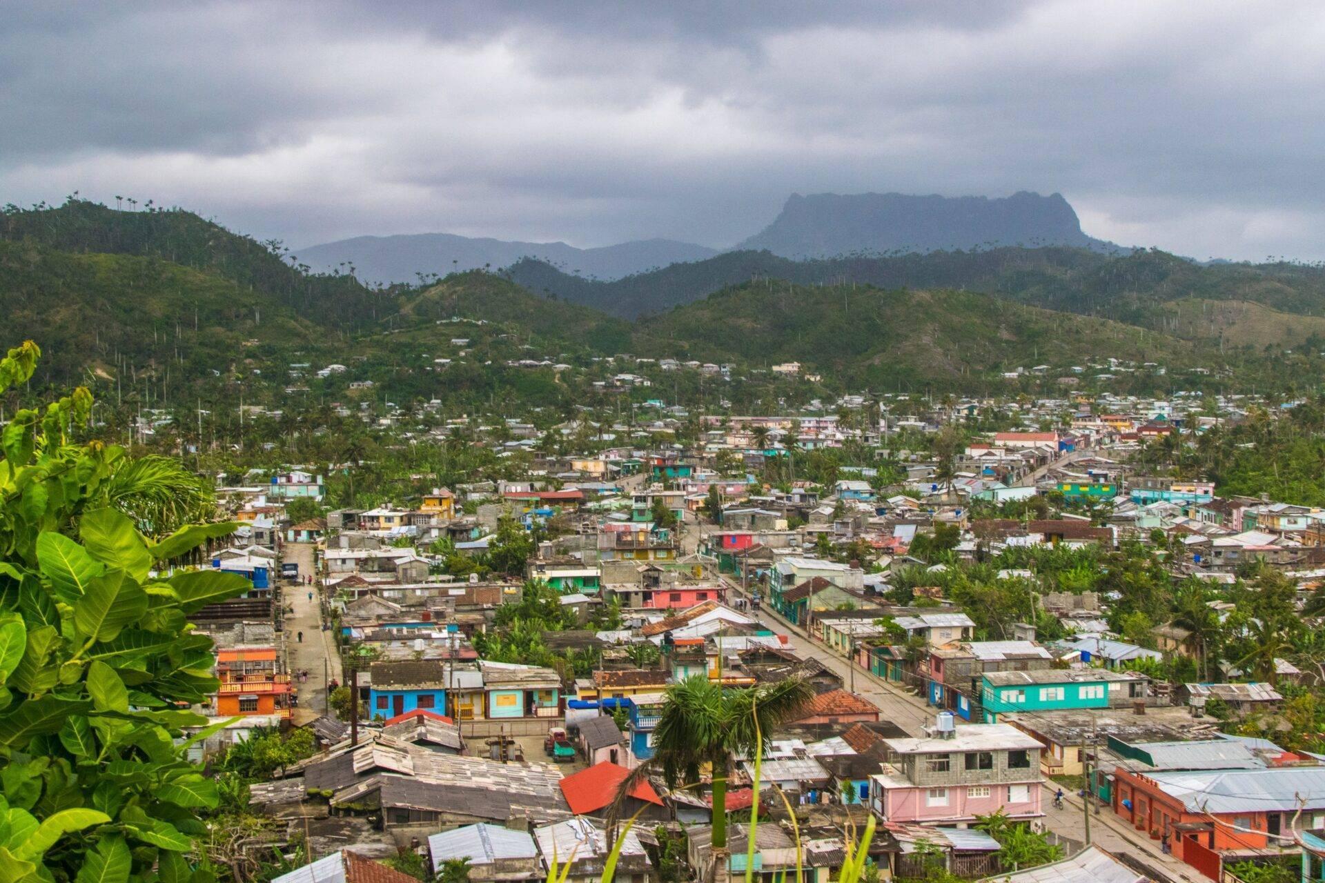 Vue aérienne d’une ville colorée nichée dans une vallée montagneuse tropicale avec maisons colorées et pics rocheux